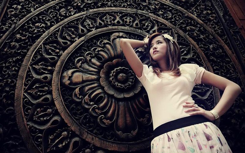 woman in front of carved wood