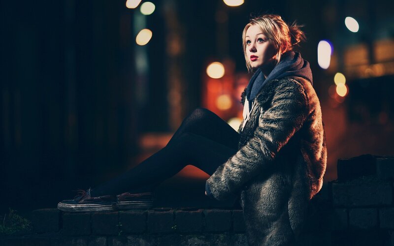 woman in fur coat at night