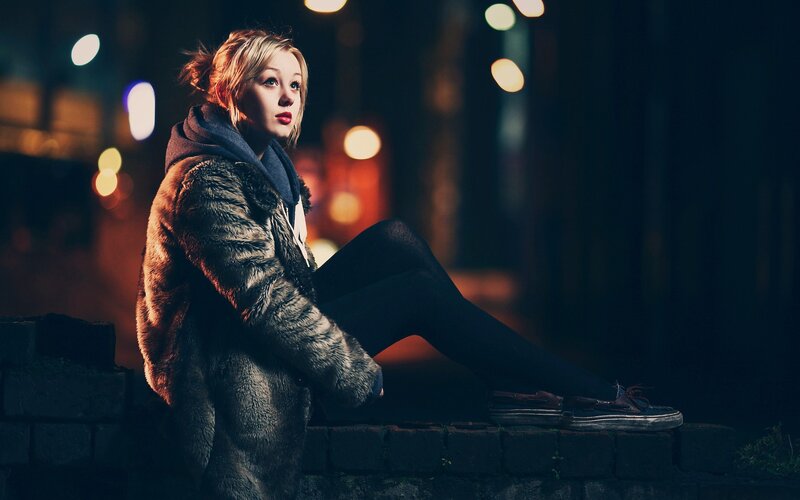 woman in fur coat at night