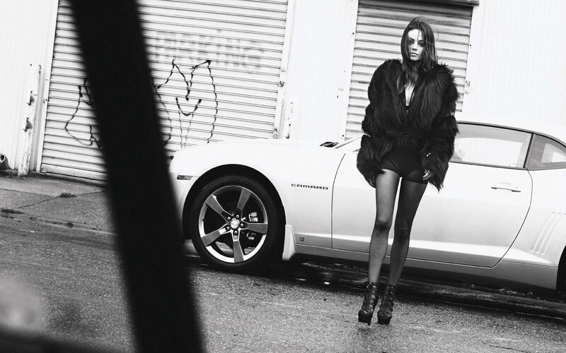 woman in fur coat by camaro