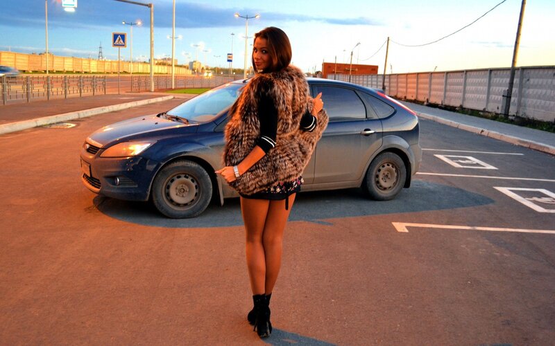 Woman in fur coat by car