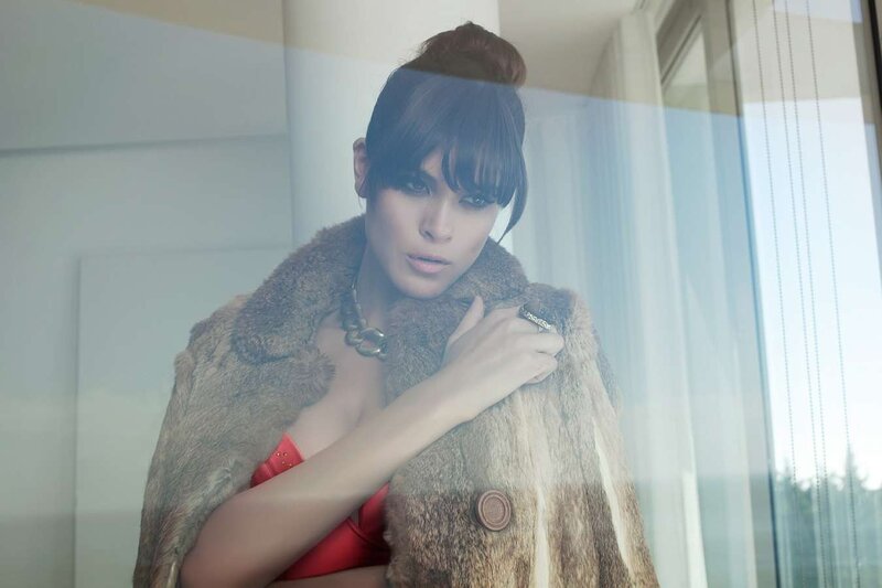 woman in fur coat by window
