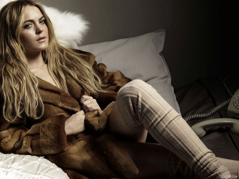 woman in fur coat on bed