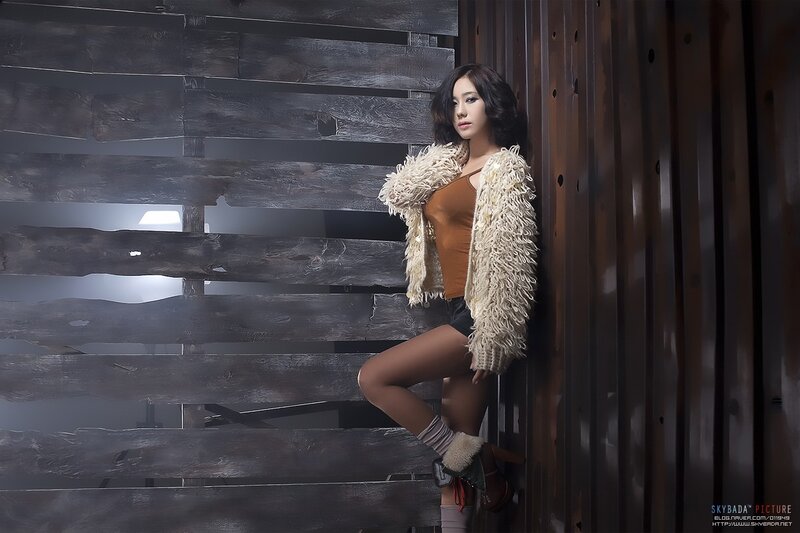 woman in fur coat on wooden stairs