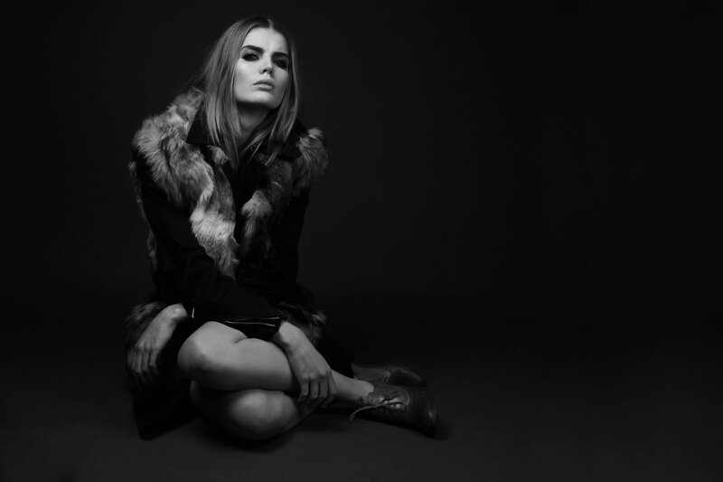 woman in fur coat sitting