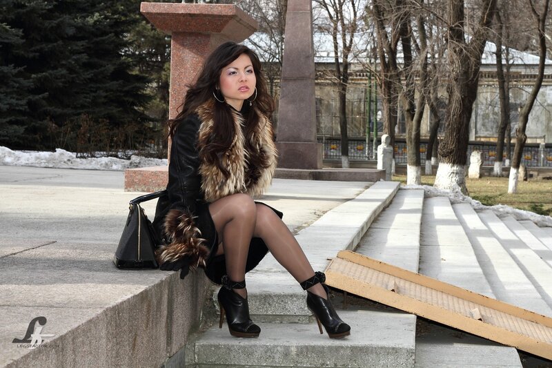 Woman in fur coat sitting on steps