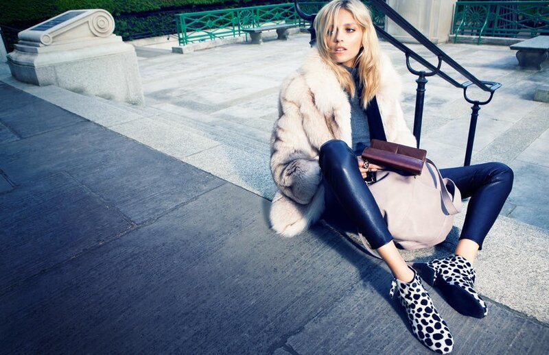 woman in fur coat sitting on steps