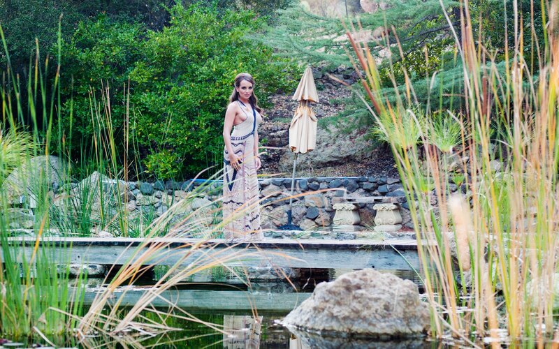 Woman in garden by pond