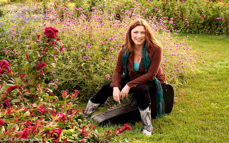 Woman in Garden with Guitar Case