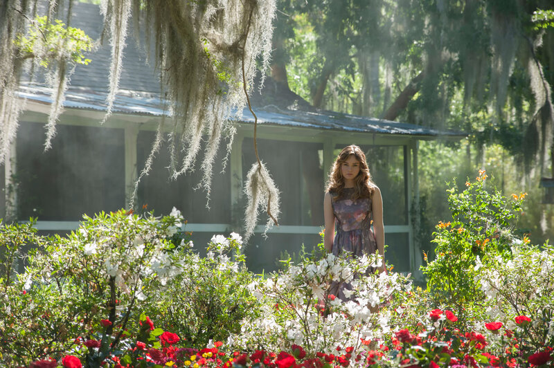 woman in garden with house