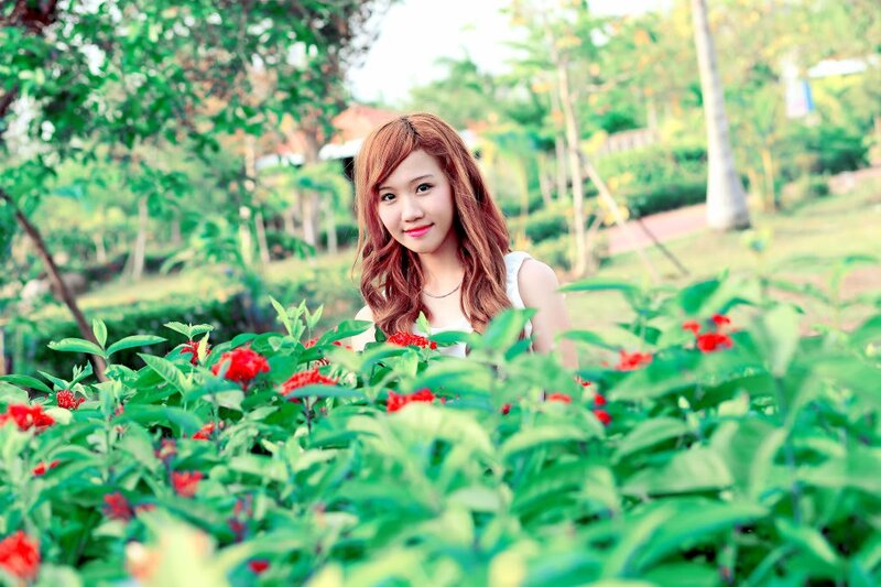 woman in garden with red flowers