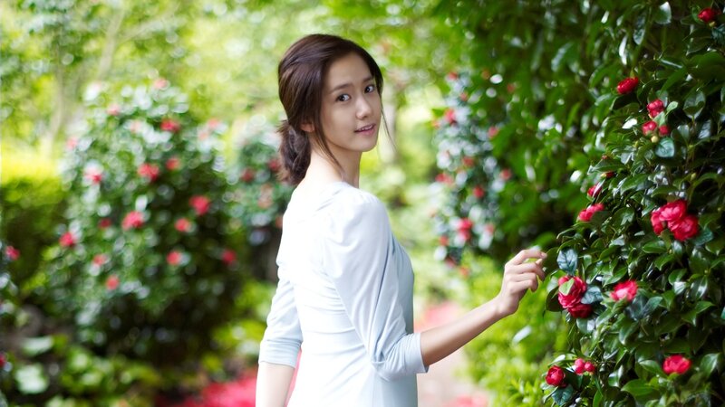 woman in garden with red flowers