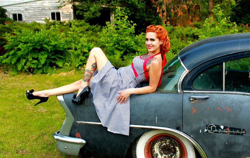 Woman in gingham dress on vintage car