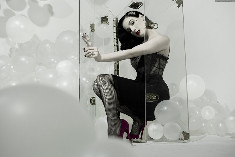 woman in glass box with balloons