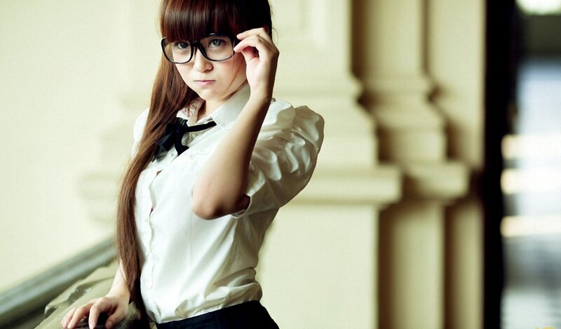 woman in glasses adjusting her frame