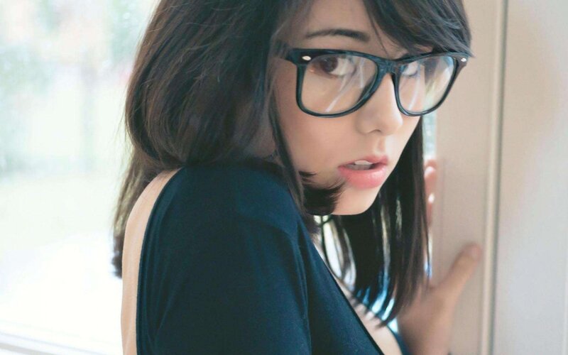 woman in glasses looking over shoulder
