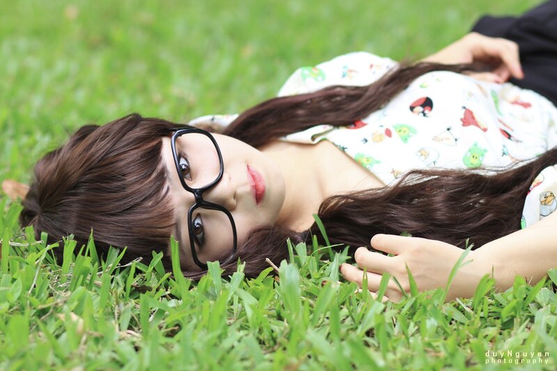 woman in glasses lying on grass