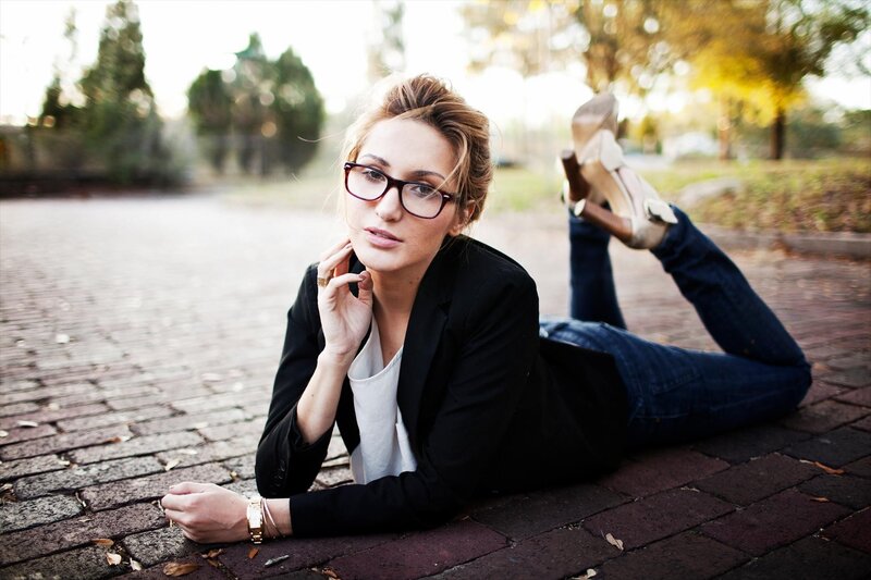 woman in glasses lying on pavement
