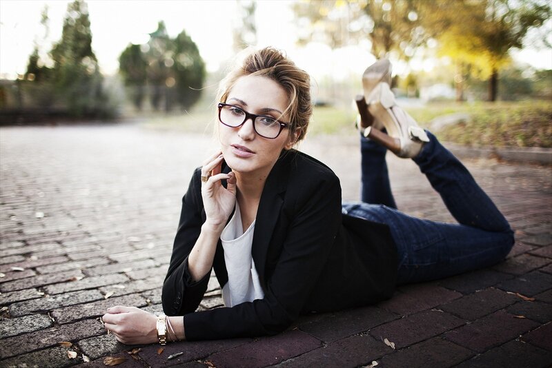 woman in glasses lying on pavement