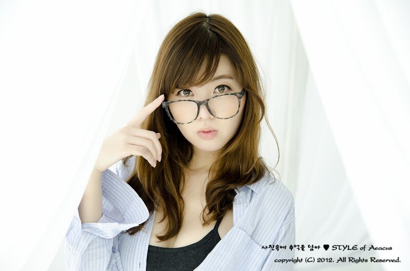 woman in glasses pointing at head