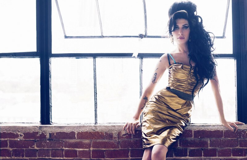 woman in gold dress by window