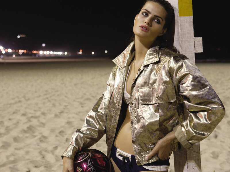 Woman in gold jacket on beach