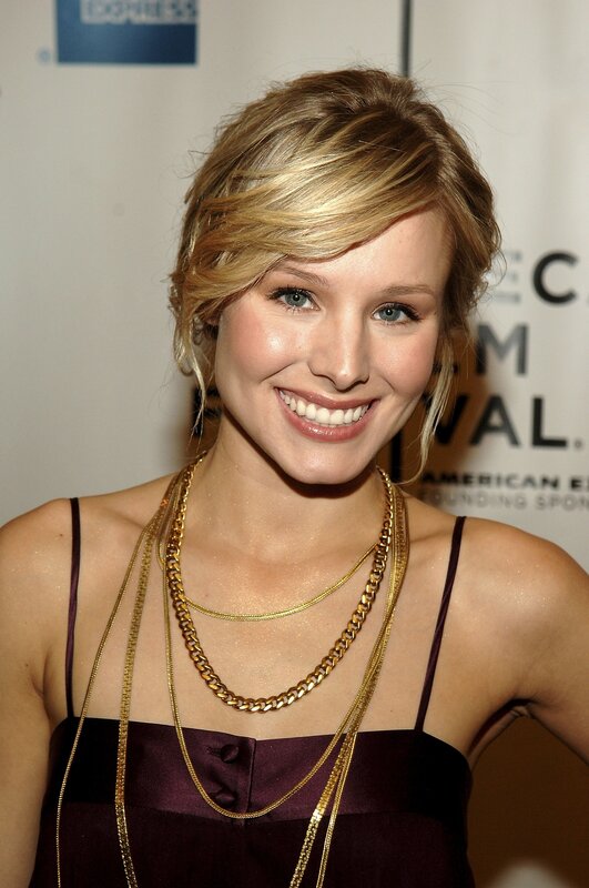 woman in gold necklaces smiling