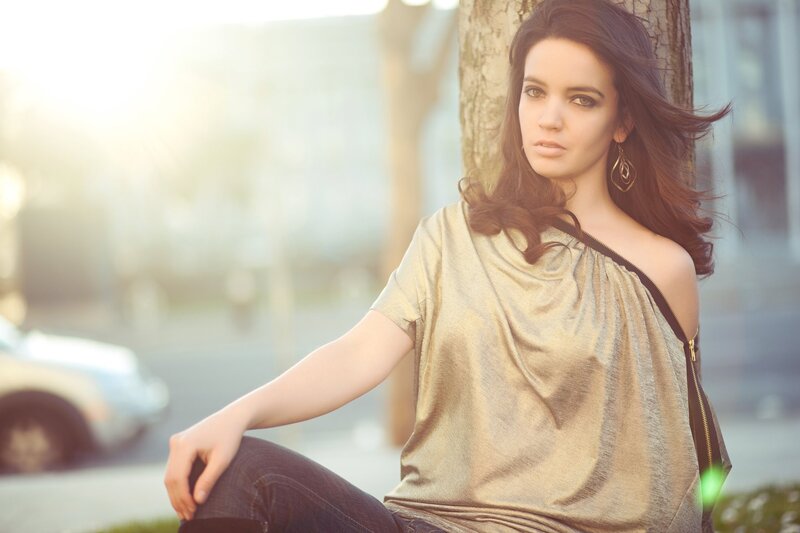woman in gold top by tree