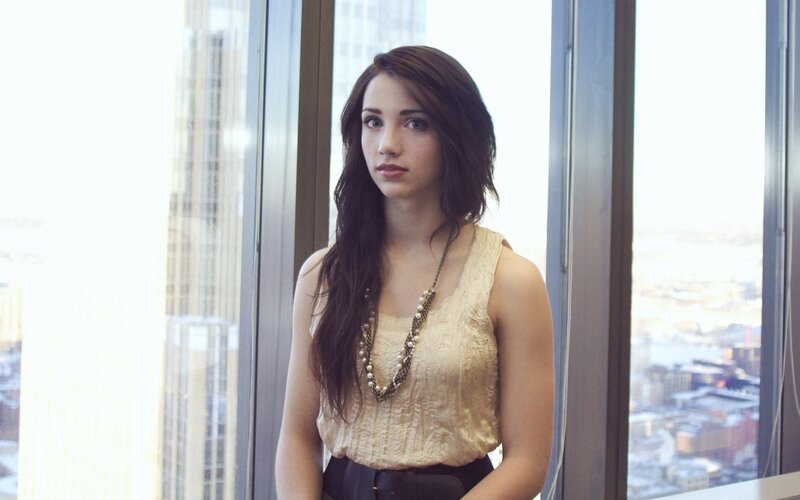 woman in gold top by window