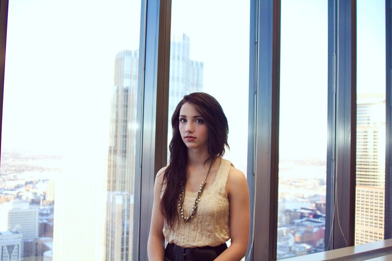 woman in gold top by window