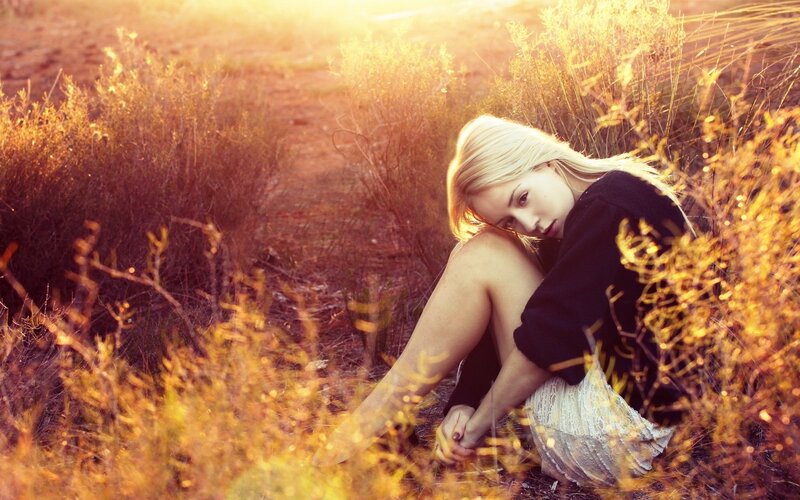 woman in golden field at sunset