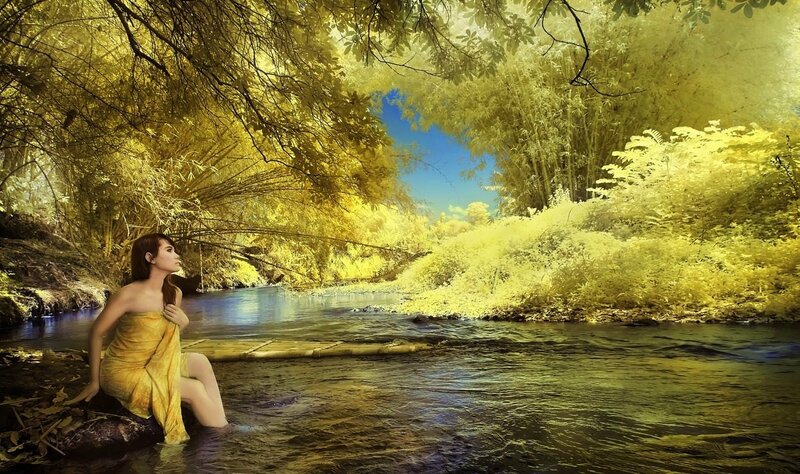 Woman in golden forest stream