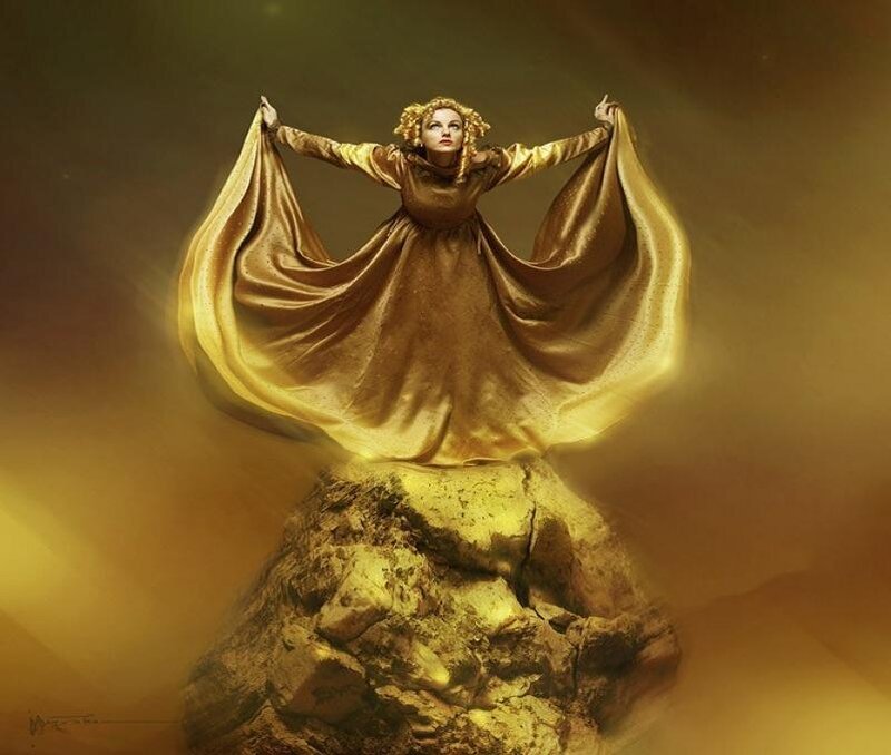 woman in golden robe on rock