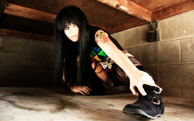 woman in goth attire crouching
