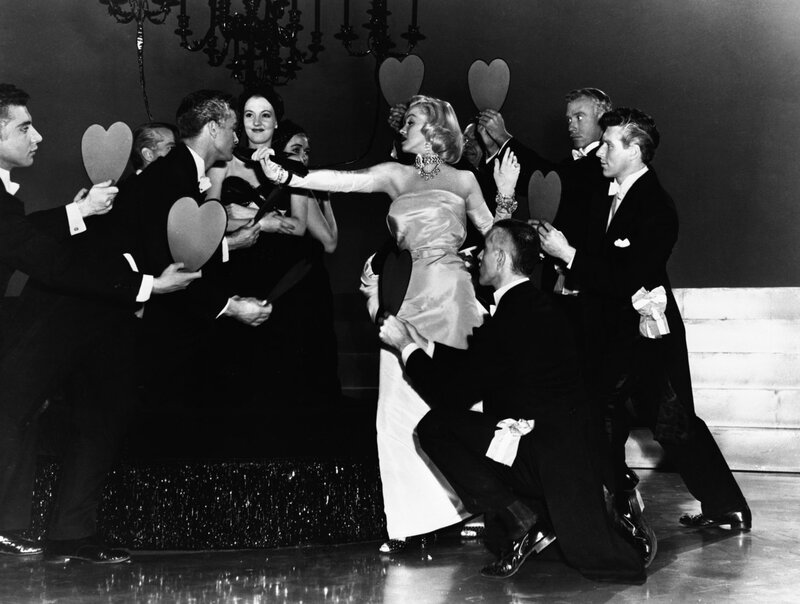 Woman in gown surrounded by men
