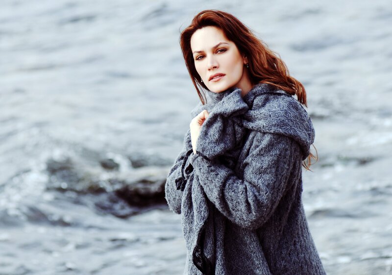 woman in gray coat by water