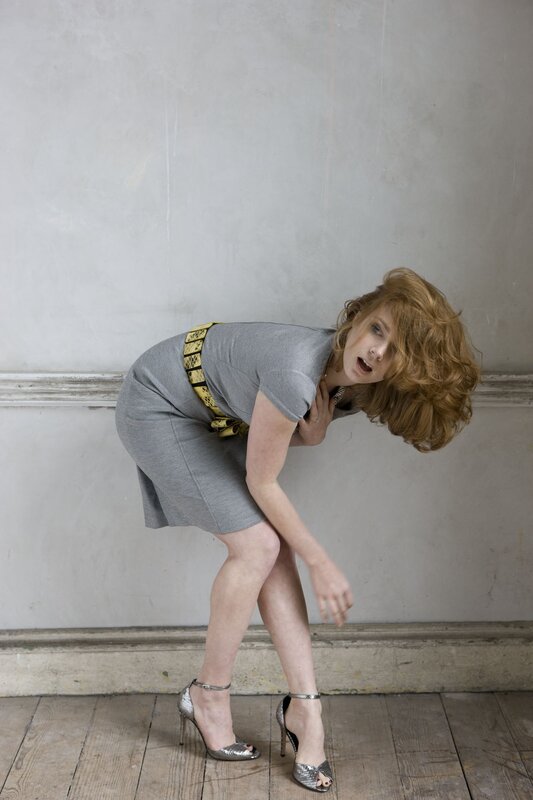 Woman in gray dress bending forward