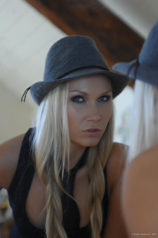 woman in gray hat looking at mirror