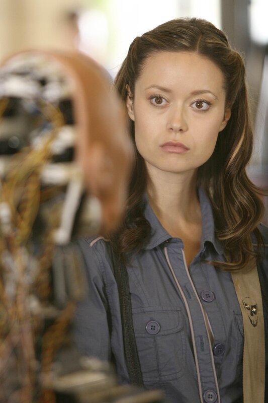 woman in gray shirt looking at robot