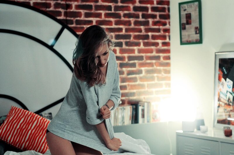 woman in gray sweater on bed