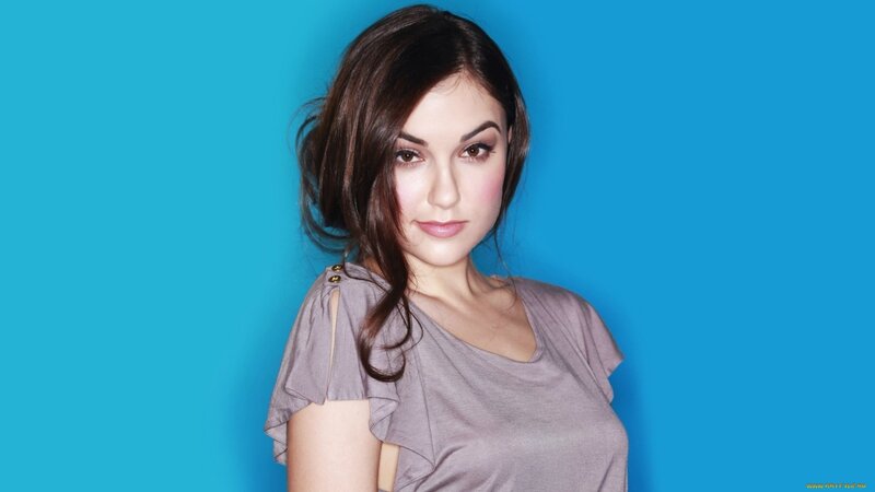 woman in gray top against blue background