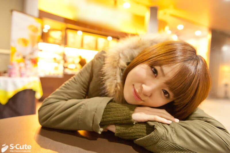 woman in green coat at cafe
