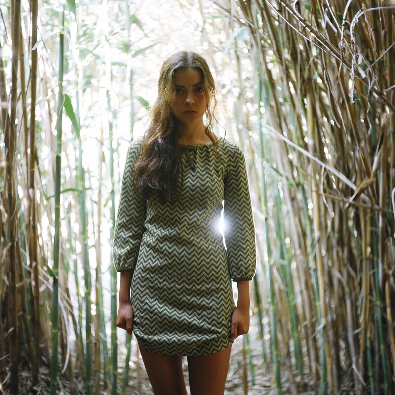 woman in green dress among reeds
