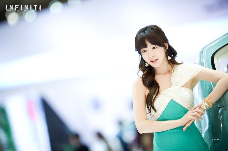 woman in green dress at auto show