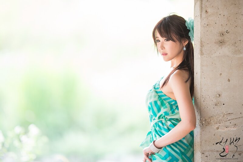 woman in green dress by concrete wall