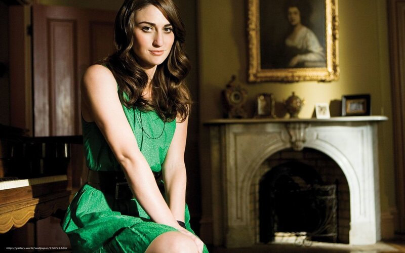 Woman in green dress by fireplace