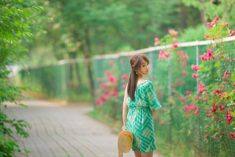 Woman in green dress by flowers