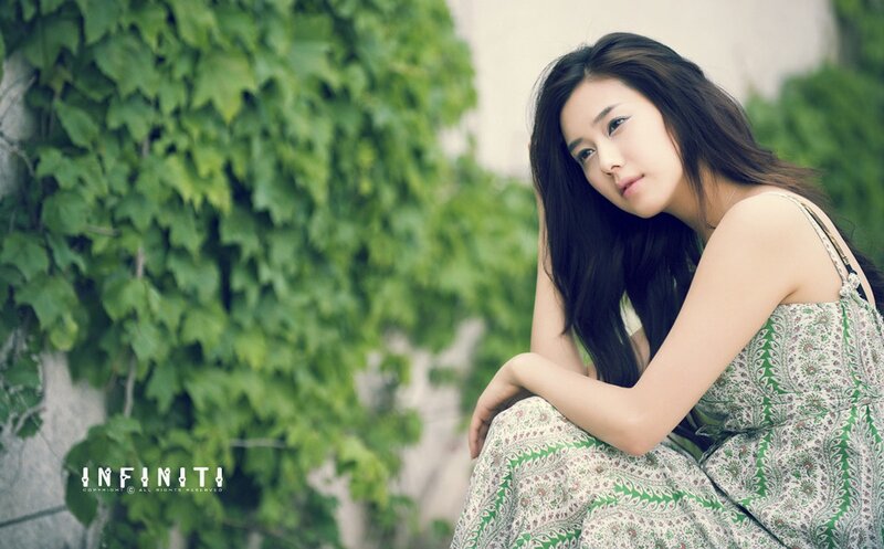 woman in green dress by ivy wall