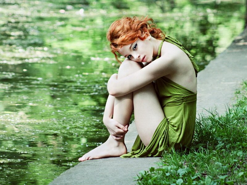 Woman in green dress by water
