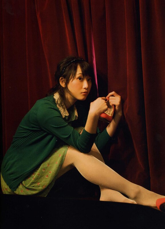 woman in green dress holding shoe